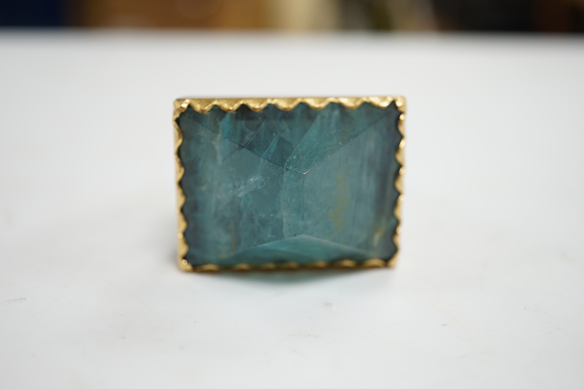 An unusual recent German 925, yellow metal and shaped cut aquamarine set architectural dress ring, the stone weighing approximately 79.00ct, size O/P, gross weight 67 grams. Condition - fair to good